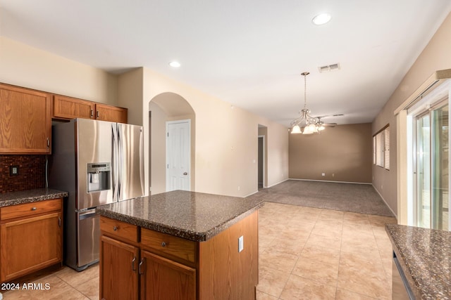 kitchen with stainless steel refrigerator with ice dispenser, tasteful backsplash, ceiling fan, a center island, and hanging light fixtures