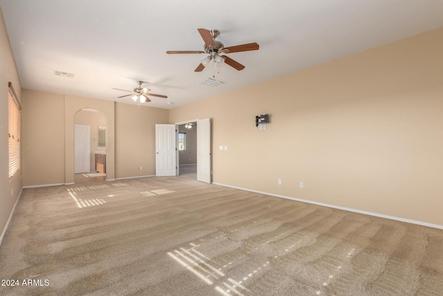 unfurnished bedroom featuring connected bathroom, light colored carpet, and ceiling fan