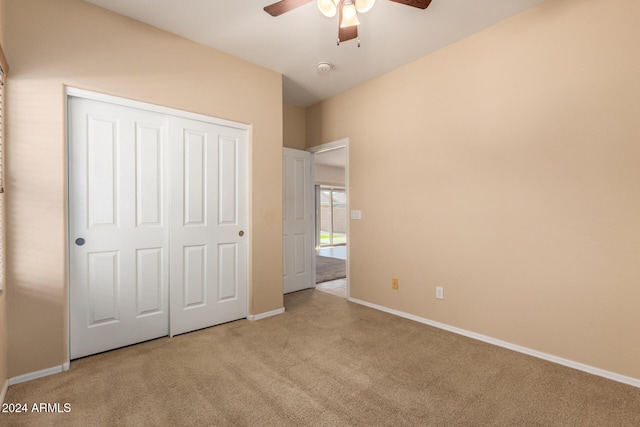 unfurnished bedroom featuring a closet, light colored carpet, and ceiling fan