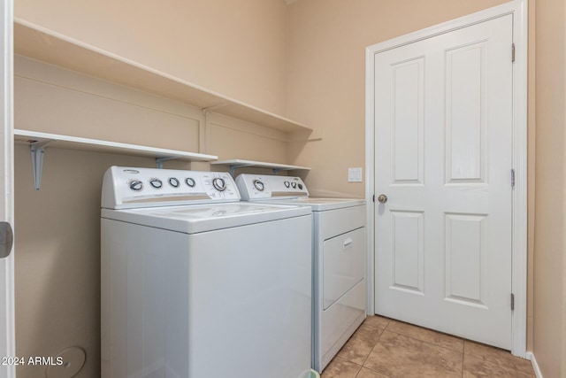 laundry area with washer and dryer and light tile patterned floors