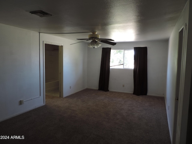 empty room with a textured ceiling, carpet, and ceiling fan