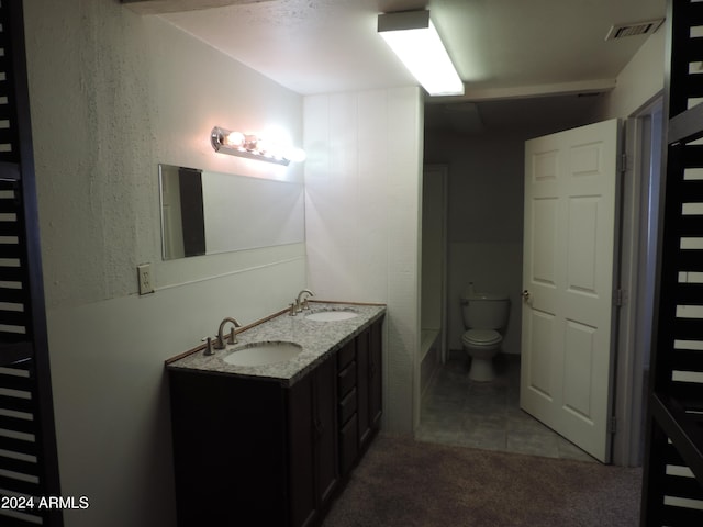 bathroom with toilet, vanity, tile patterned floors, and a bathtub