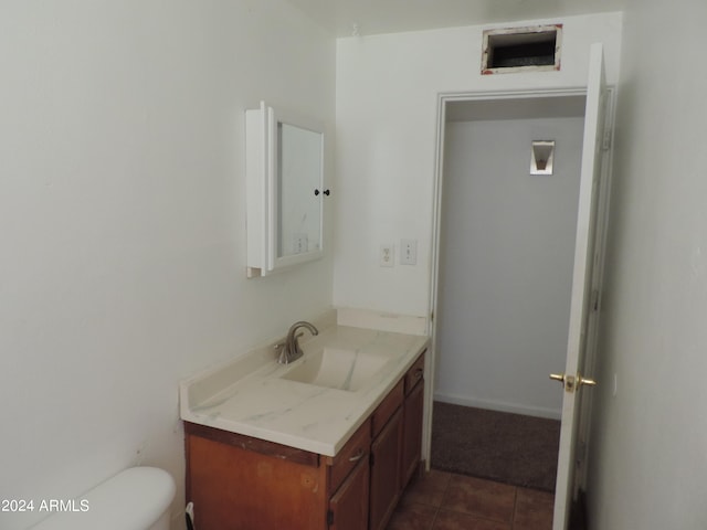 bathroom featuring vanity, toilet, and tile patterned flooring