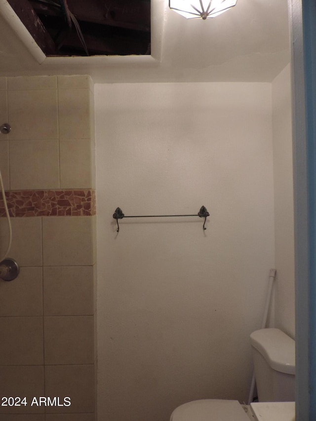 bathroom featuring toilet and a tile shower