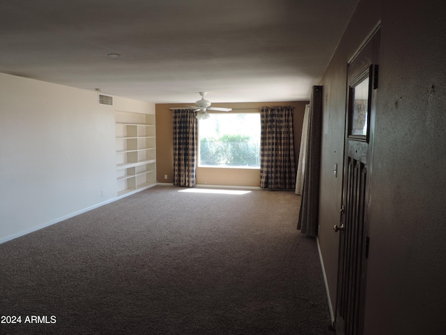 unfurnished room featuring ceiling fan, carpet flooring, and built in shelves