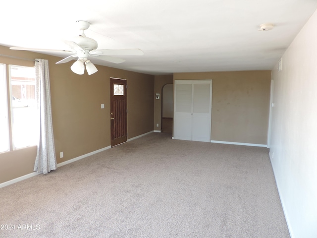 unfurnished room featuring light colored carpet and ceiling fan