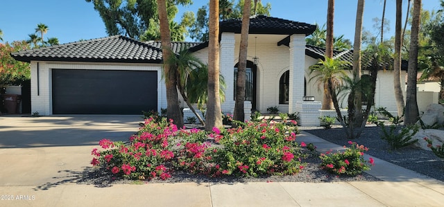 7724 E Charter Oak Rd, Scottsdale, AZ 85260 - view of front of house featuring driveway, brick siding, and a tiled roof