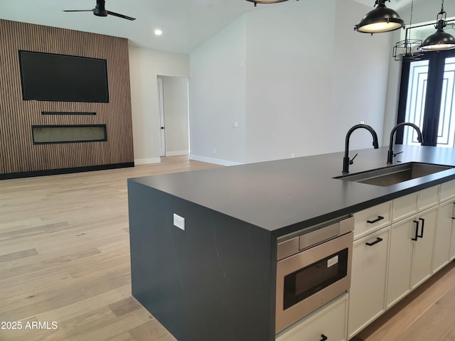 7724 E Charter Oak Rd, Scottsdale, AZ 85260 - kitchen with stainless steel microwave, light wood finished floors, dark countertops, and recessed lighting