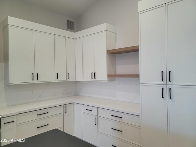 7724 E Charter Oak Rd, Scottsdale, AZ 85260 - kitchen featuring open shelves, white cabinets, tasteful backsplash, and light stone countertops