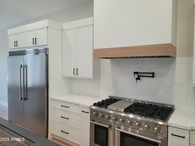 7724 E Charter Oak Rd, Scottsdale, AZ 85260 - kitchen with premium appliances, tasteful backsplash, light stone counters, and white cabinetry