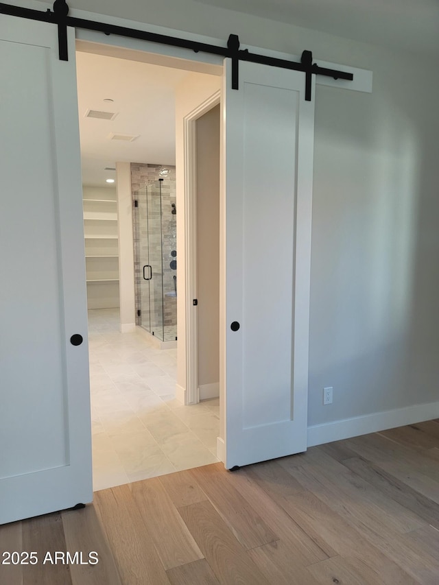 7724 E Charter Oak Rd, Scottsdale, AZ 85260 - hall featuring a barn door and light wood-type flooring