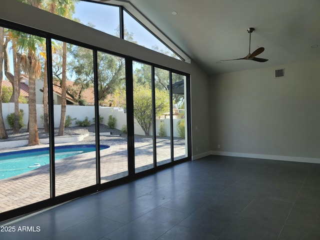 7724 E Charter Oak Rd, Scottsdale, AZ 85260 - empty room with vaulted ceiling, dark tile patterned flooring, and a ceiling fan