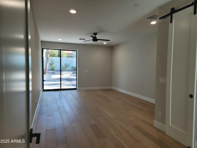 7724 E Charter Oak Rd, Scottsdale, AZ 85260 - unfurnished room featuring a ceiling fan, a barn door, light wood-style flooring, and recessed lighting