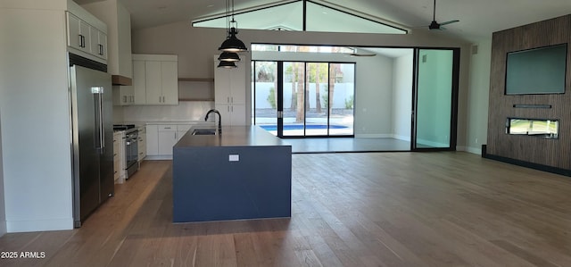 7724 E Charter Oak Rd, Scottsdale, AZ 85260 - kitchen featuring high quality appliances, open floor plan, an island with sink, light wood-type flooring, and white cabinetry