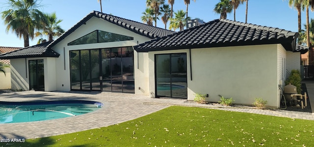 7724 E Charter Oak Rd, Scottsdale, AZ 85260 - rear view of property featuring a patio, stucco siding, a lawn, an outdoor pool, and a tile roof