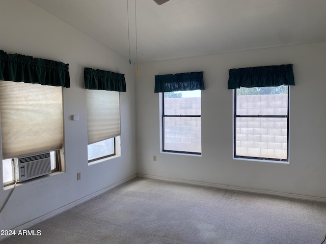 carpeted spare room featuring cooling unit and vaulted ceiling