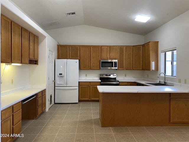 kitchen with lofted ceiling, sink, light tile patterned flooring, kitchen peninsula, and stainless steel appliances