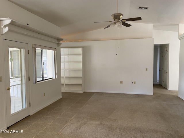 empty room with light colored carpet, vaulted ceiling, and ceiling fan