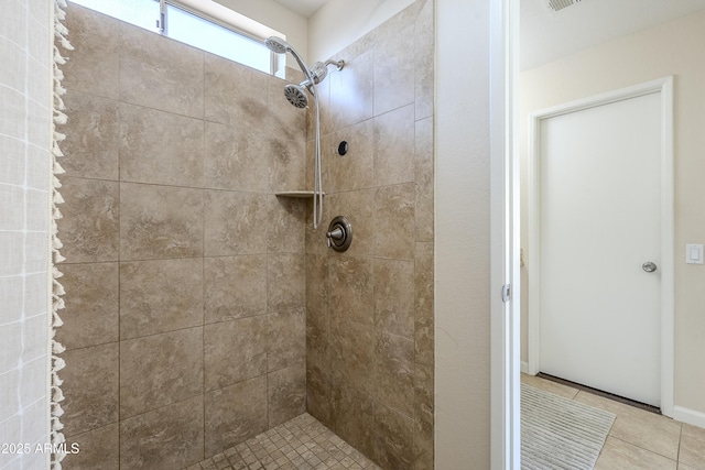 bathroom featuring tile patterned floors and a tile shower