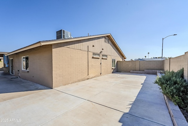 view of side of property with cooling unit and a patio area