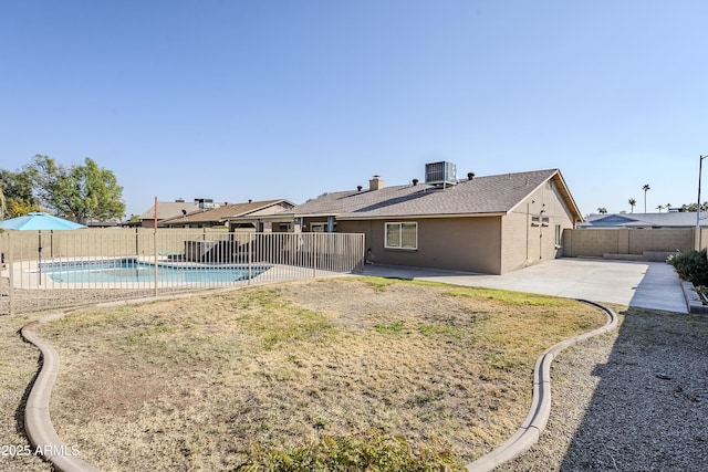 back of property with a fenced in pool, a patio area, and central air condition unit