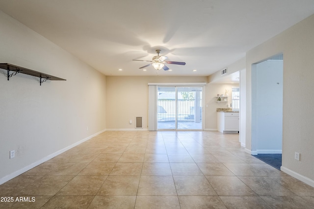 tiled empty room featuring ceiling fan