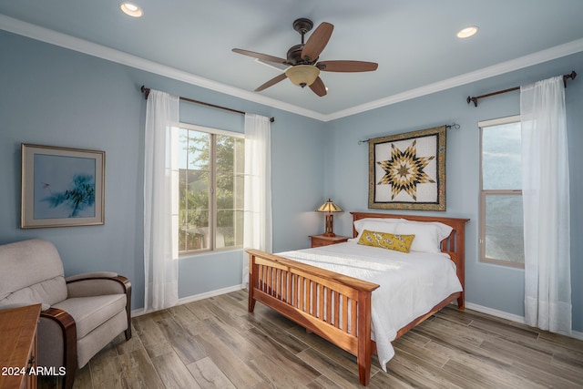 bedroom featuring hardwood / wood-style flooring, ceiling fan, and crown molding