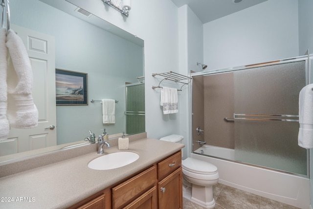 full bathroom with tile patterned flooring, vanity, toilet, and bath / shower combo with glass door