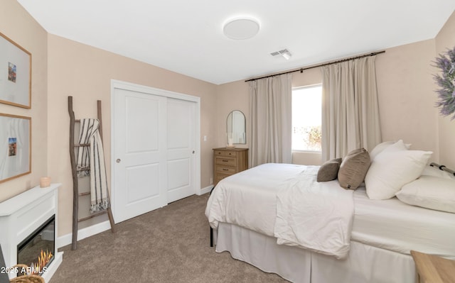 5971 E Orange Blossom Ln, Phoenix, AZ 85018 - bedroom featuring light carpet, a closet, and a glass covered fireplace