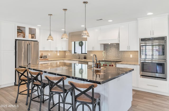 5971 E Orange Blossom Ln, Phoenix, AZ 85018 - kitchen featuring stainless steel appliances, premium range hood, an island with sink, decorative backsplash, and recessed lighting