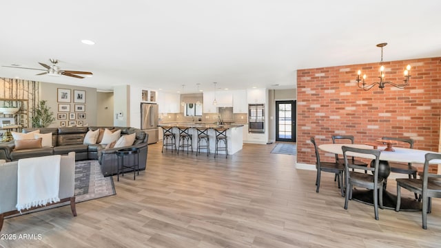 5971 E Orange Blossom Ln, Phoenix, AZ 85018 - living room featuring a chandelier, ceiling fan, light wood finished floors, and recessed lighting