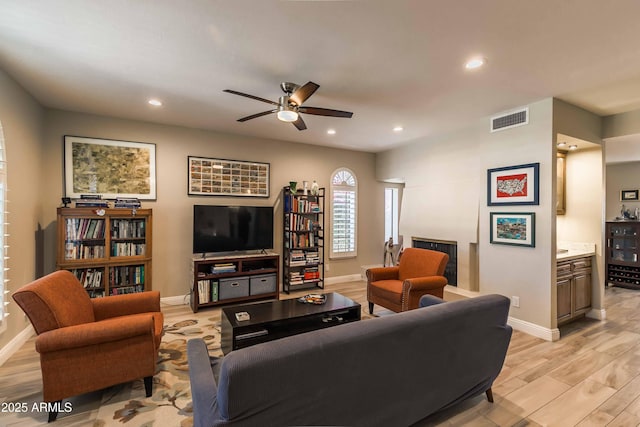 living room with ceiling fan and light wood-type flooring