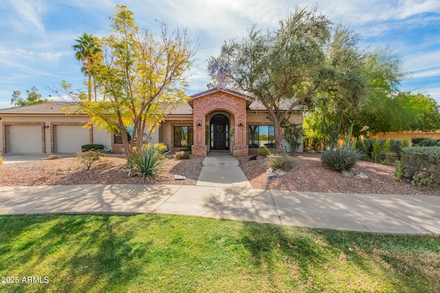 mediterranean / spanish home with a garage and a front yard