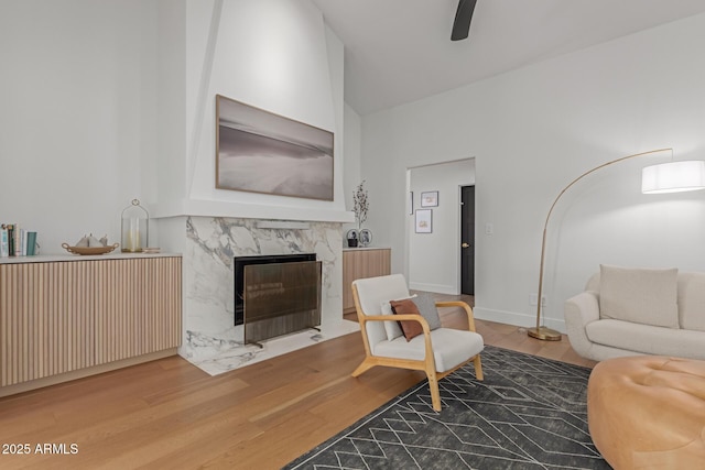 living room featuring hardwood / wood-style flooring, a high end fireplace, and high vaulted ceiling