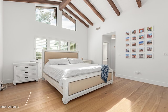 bedroom with high vaulted ceiling, light hardwood / wood-style floors, and beamed ceiling