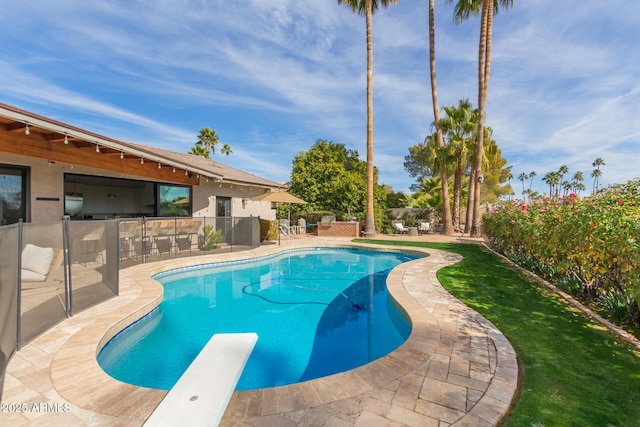 view of swimming pool featuring a diving board and a patio area