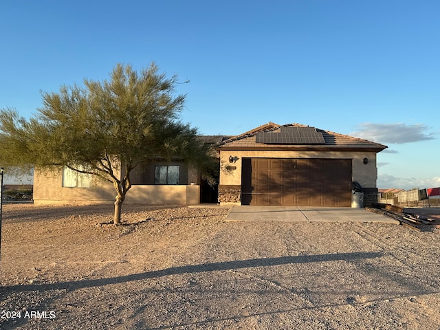 view of front facade with a garage and solar panels