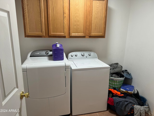 clothes washing area with cabinets and separate washer and dryer