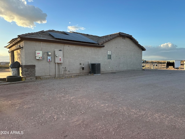 view of side of home featuring solar panels and central air condition unit