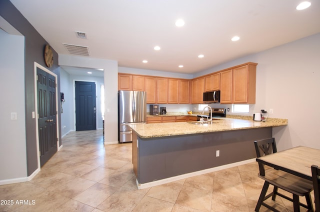 kitchen featuring sink, kitchen peninsula, light stone countertops, and stainless steel appliances