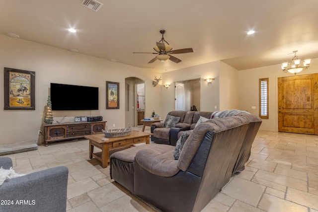 living room with ceiling fan with notable chandelier