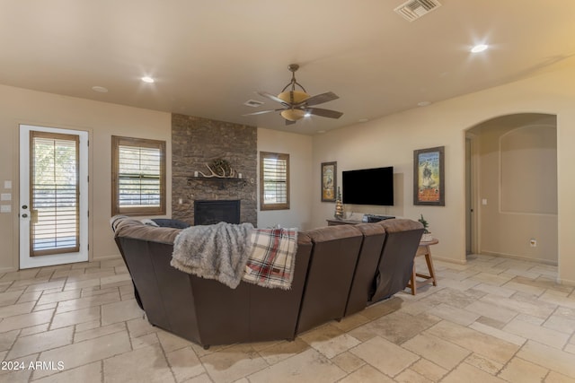 living room featuring ceiling fan and a fireplace