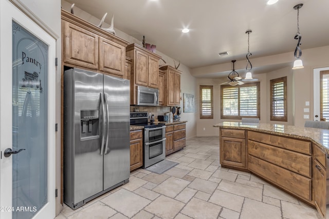 kitchen featuring ceiling fan, appliances with stainless steel finishes, decorative light fixtures, tasteful backsplash, and light stone counters