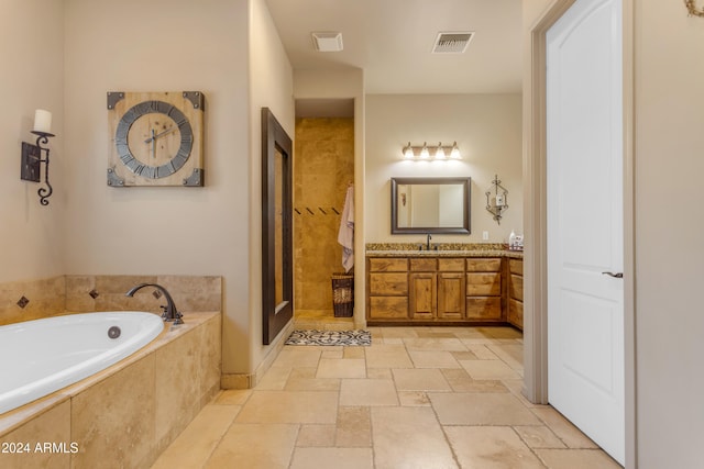 bathroom featuring vanity and independent shower and bath