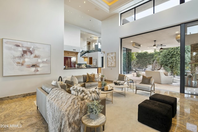 carpeted living room featuring a wealth of natural light, ceiling fan, and a towering ceiling