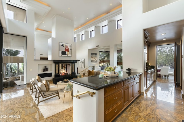 kitchen featuring a multi sided fireplace and a towering ceiling