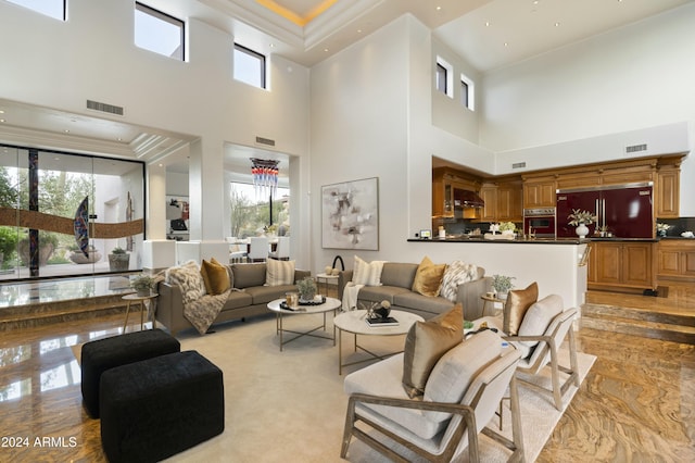 living room with a high ceiling, a wealth of natural light, and crown molding