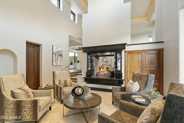 sitting room with a high end fireplace and a high ceiling