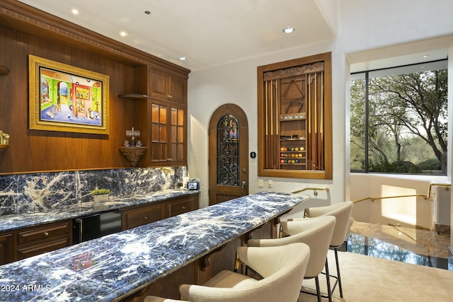 bar featuring tasteful backsplash and dark stone counters