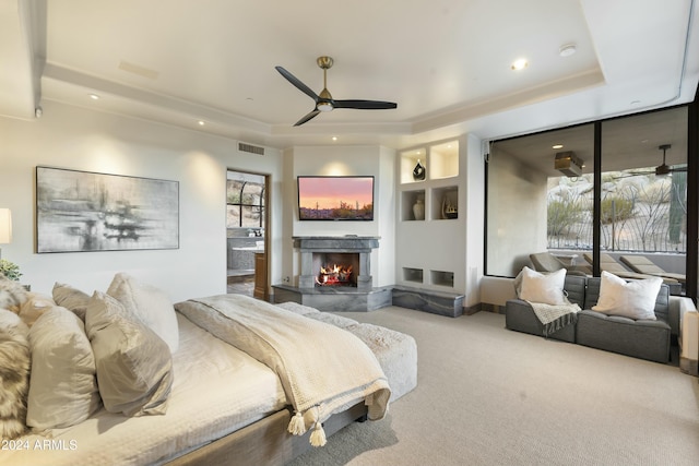 bedroom featuring carpet floors, a tray ceiling, and ceiling fan